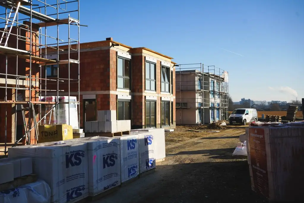 Das Bild zeigt drei Flachdachhäuser während der Bauphase im Baugebiet Jöllheide in Bielefeld.