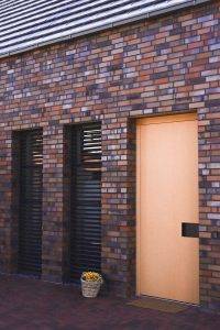 Bild eines Hauseingangsbereiches mit Klinkerfassade und Raffstoren.